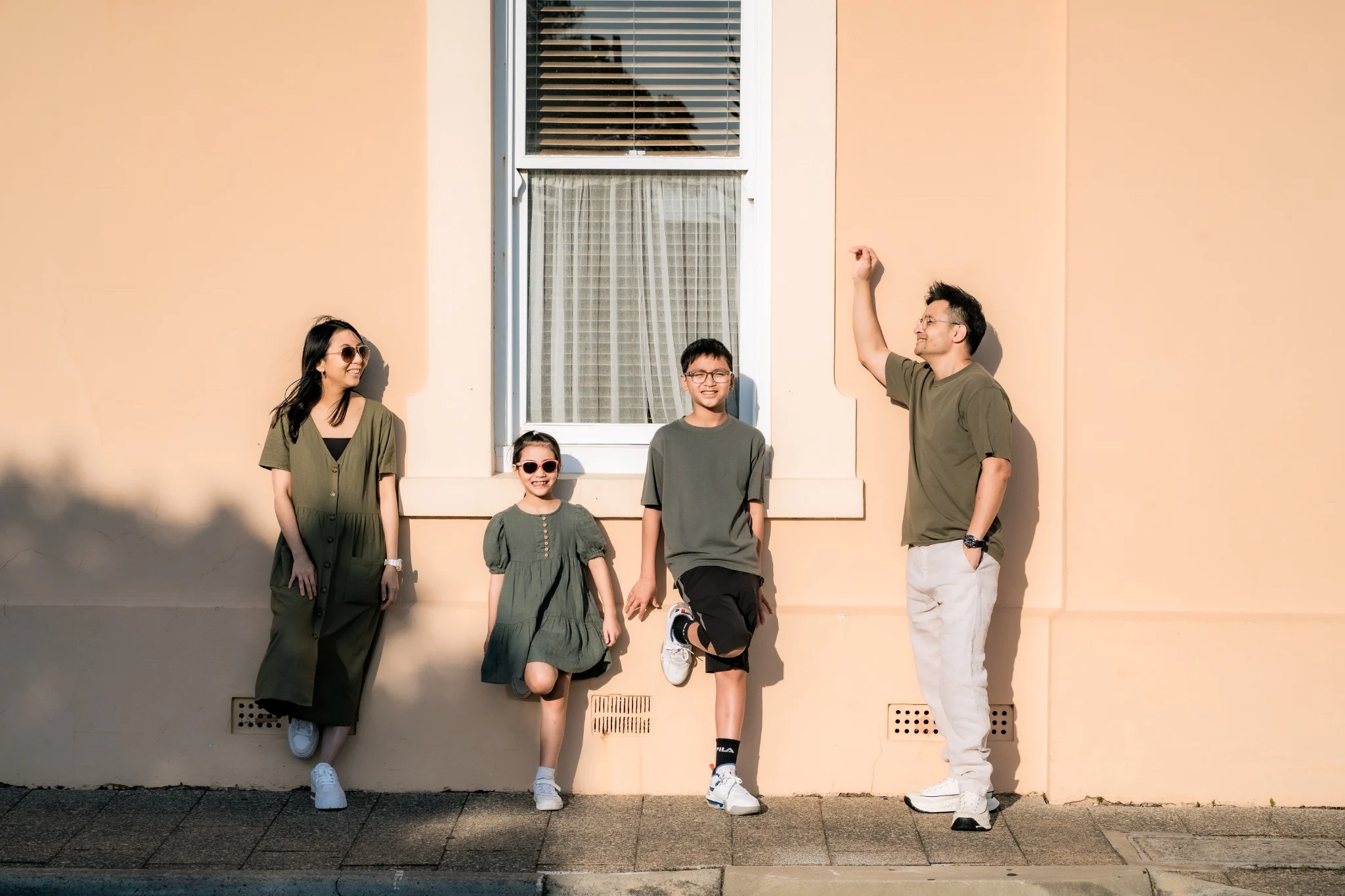 The Chan's Family standing together by a sunlit heritage wall in Fremantle, Perth, Western Australia
