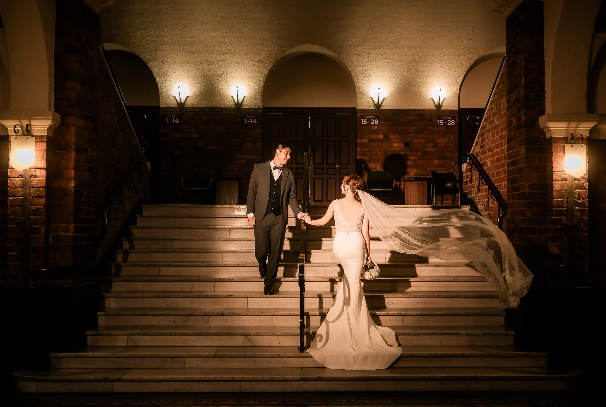 Melody and Ken on the grand staircase with a flowing veil at UWA in Perth, Western Australia