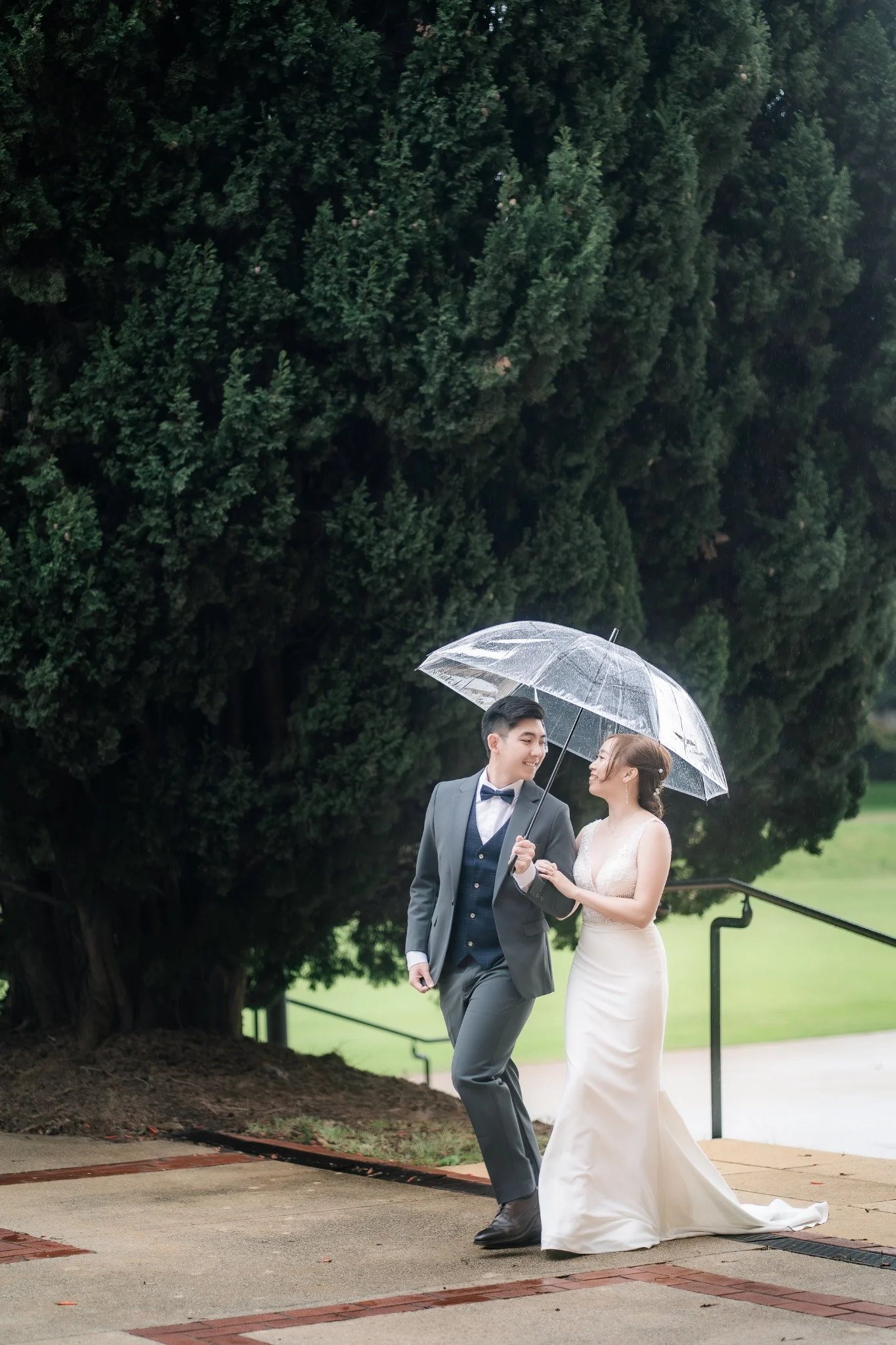 Melody and Ken walking beneath an umbrella at UWA in Perth, Western Australia