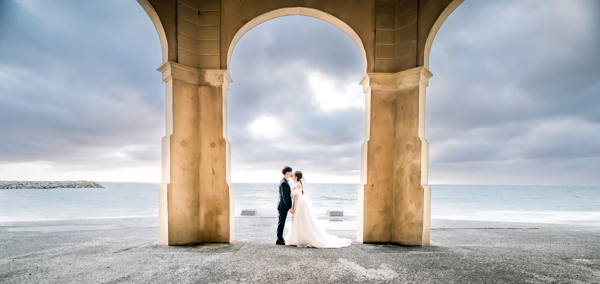 Noel and Brian framed by coastal arches at Cottesloe