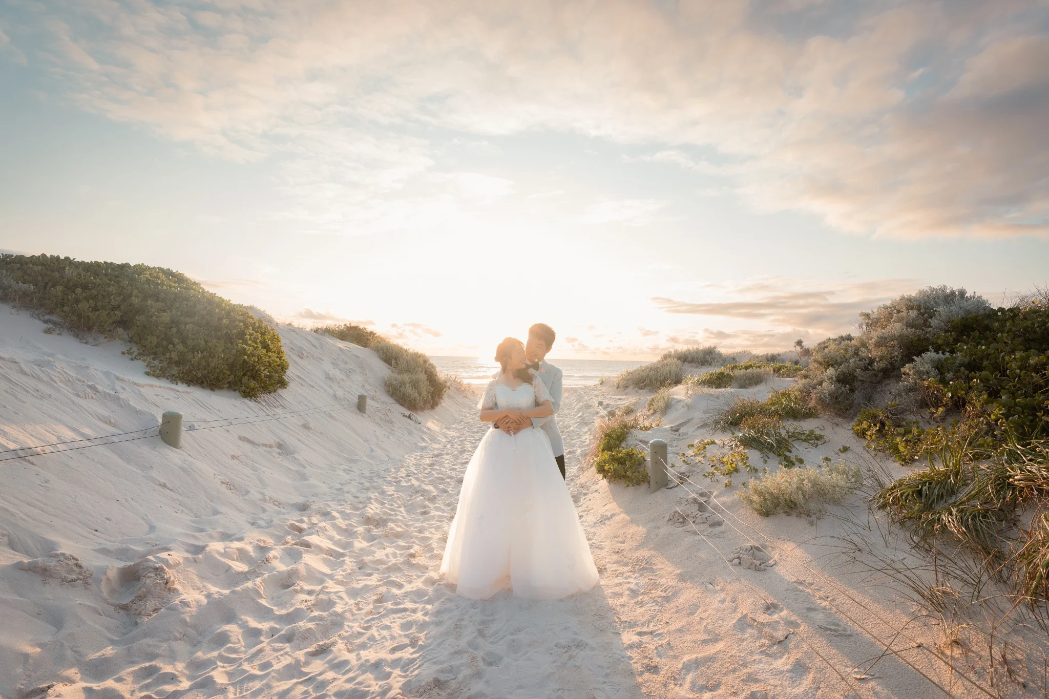 Couple embracing among white coastal dunes during a Perth pre-wedding photography session
